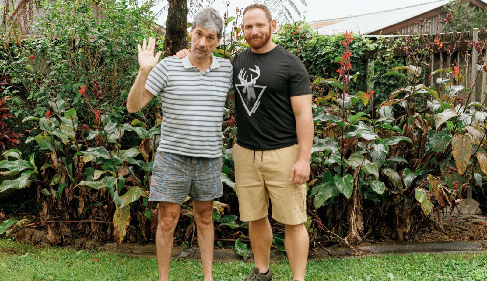 An i'ara participant waving beside their Support Coordinator in a tropical Far North Queensland garden